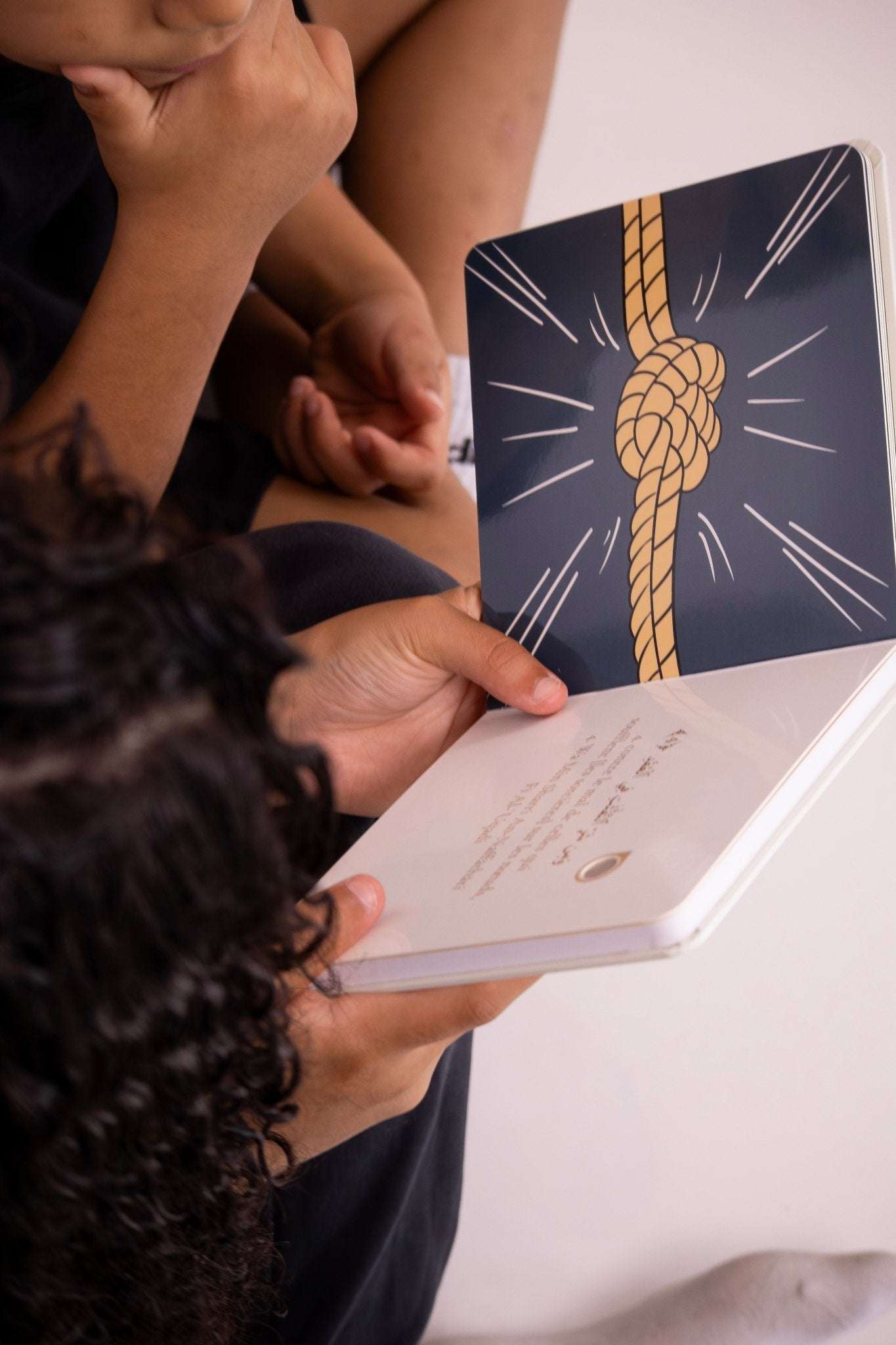 Enfant lisant un livre illustré avec un nœud sur la couverture, 3-teiliges Hörbuch-Set pour apprendre les premières sourates en arabe et allemand